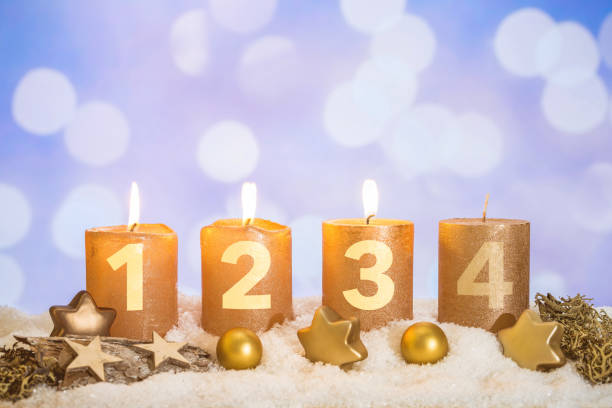 Three golden advent candles lit in snow Four numbered gold advent candles with three candles lit and christmas decoration lying in snow as template unlit match stock pictures, royalty-free photos & images