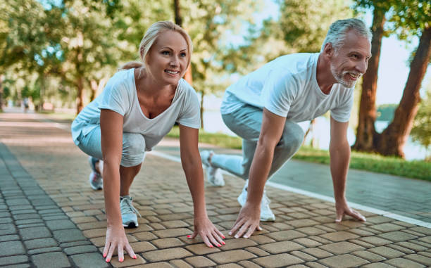 casal sênior fazer esporte ao ar livre - middle human age couple women - fotografias e filmes do acervo