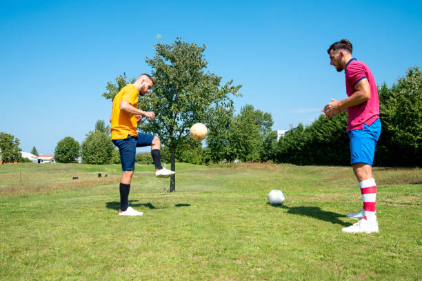 istock Two Young Males Playing On Golf Course With Soccer Ball 1067793130