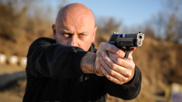 istock Police agent bodyguard gun pointing pistol to attacker. Front view 1067799364