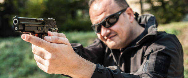 istock Police agent bodyguard gun pointing pistol to attacker. Front view 1067799568