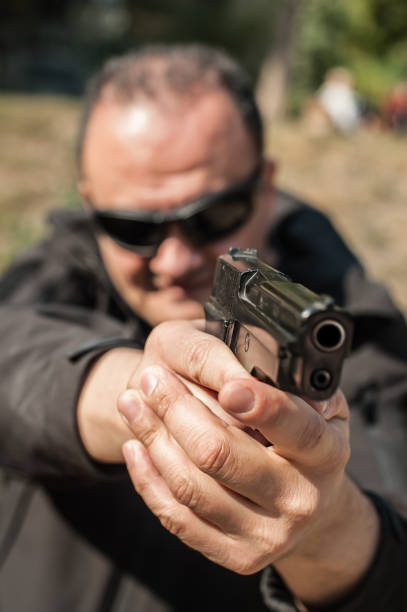 istock Police agent bodyguard gun pointing pistol to attacker. Front view 1067799728