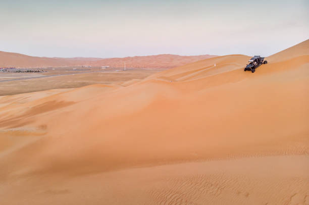 istock dune buggy driving down a massive sand dune in Liwa desert 1067800552