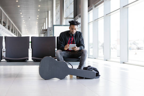 istock Funky young man waiting for flight in airport lounge 1067802634