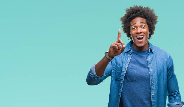 istock Afro american man over isolated background pointing finger up with successful idea. Exited and happy. Number one. 1067803450