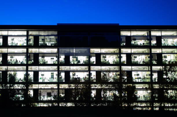 istock Modern architecture office building illuminated at night outdoors blue hour people working 1067803718