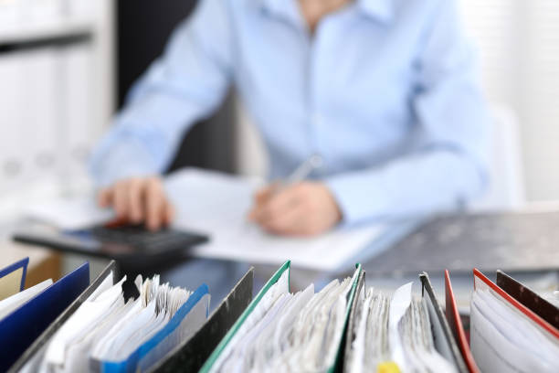 carpetas con papeles están esperando para ser procesados con la empresaria o secretario en blur. - desk corporate business business paper fotografías e imágenes de stock