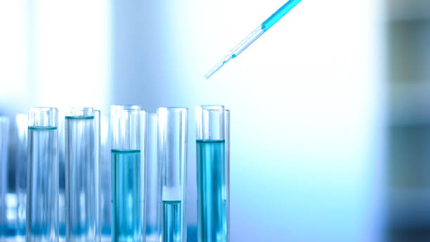 istock Laboratory worker pouring blue liquid in tubes, cleaning detergent production 1067805756