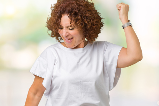Beautiful middle ager senior woman wearing white t-shirt over isolated background Dancing happy and cheerful, smiling moving casual and confident listening to music