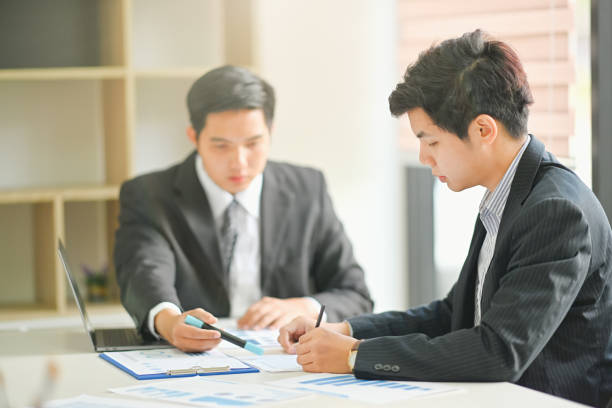 istock Two business People Planning Strategy Analysis from financial document report in office 1067809756