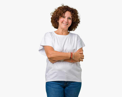 Beautiful middle ager senior woman wearing white t-shirt over isolated background happy face smiling with crossed arms looking at the camera. Positive person.