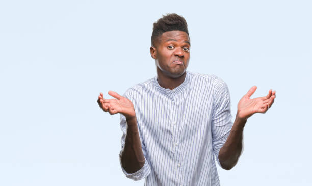 istock Young african american man over isolated background clueless and confused expression with arms and hands raised. Doubt concept. 1067813640