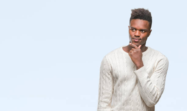 istock Young african american man over isolated background with hand on chin thinking about question, pensive expression. Smiling with thoughtful face. Doubt concept. 1067813994