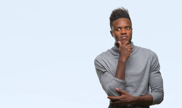istock Young african american man over isolated background looking confident at the camera with smile with crossed arms and hand raised on chin. Thinking positive. 1067814018