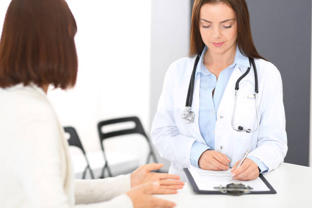istock Doctor and  patient  discussing something while standing near reception desk in emergency hospital. Physician at work in clinic. Medicine and health care concept. 1067816332