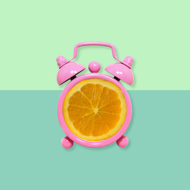 istock Orange fruit slice on alarm clock, Minimal concept. 1067818800
