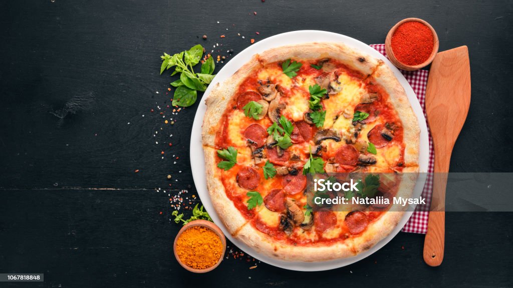 Pizza with Bavarian sausages, mushrooms and mozzarella cheese. On a wooden background. Top view. Free copy space. Bavaria Stock Photo