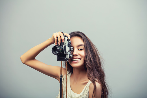 Model young fashionable beautiful girl with natural makeup in dress with retro camera fashionable Studio shot