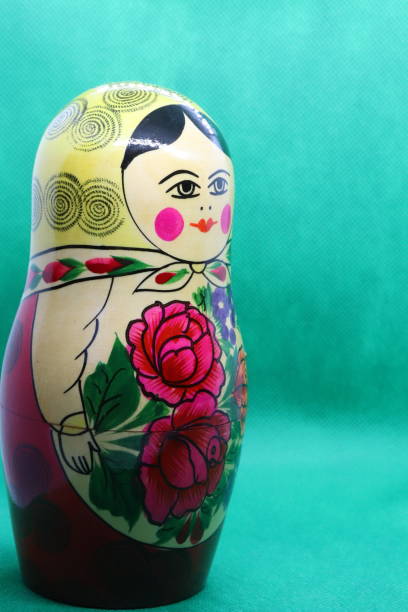 木、緑の背景に対してロシアの人形を塗装 - babushka russian nesting doll doll green ストックフォトと画像