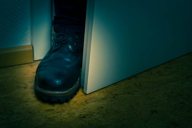 Burgler blocking door with boot stock photo