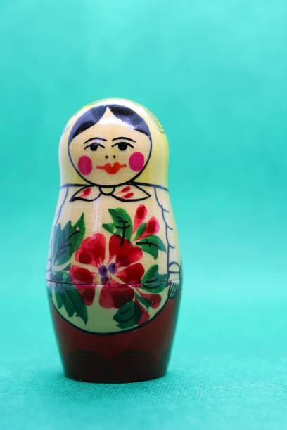 木、緑の背景に対してロシアの人形を塗装 - babushka russian nesting doll doll green ストックフォトと画像