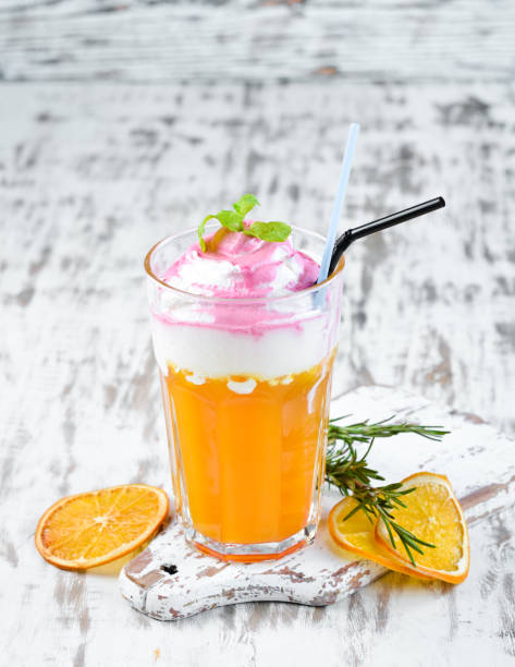Cocktail Peach Paradise. Peach juice, cream, cherry syrup. On a wooden background. Top view. Free copy space.