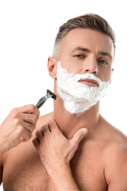 istock confident man with foam on face shaving with razor isolated on white 1067832436