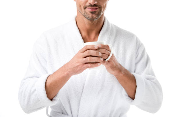 istock partial view of man in bathrobe holding coffee cup isolated on white 1067833800