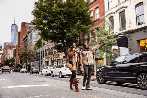 Millennial couple walking in Soho - New York, USA.