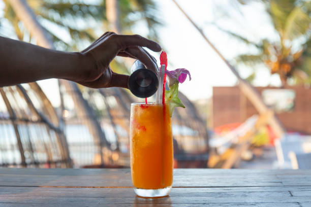 Barteder making tequila sunrise cocktail in bar by the beach.