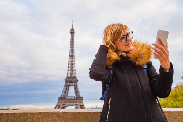 istock Girl using cellphone with Paris city background and Eiffel tower. 1067848494