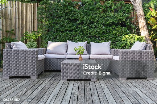 istock Large terrace patio with rattan garden furniture in the garden on wooden floor. 1067851152