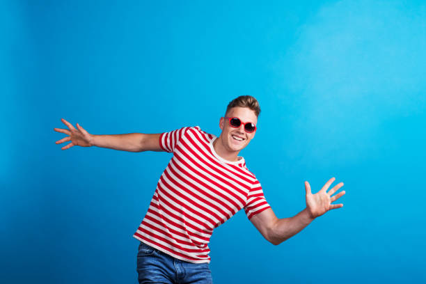 istock A young man with red sunglasses standing in a studio, having fun. 1067851168