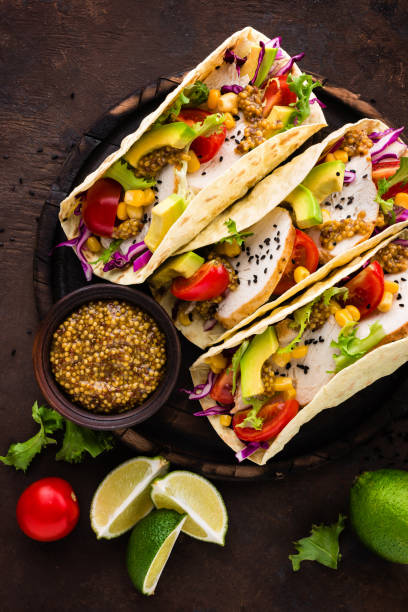 istock Mexican tacos with chicken meat, vegetables and fresh greens 1067861894