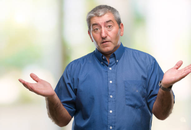 istock Handsome senior man over isolated background clueless and confused expression with arms and hands raised. Doubt concept. 1067862126