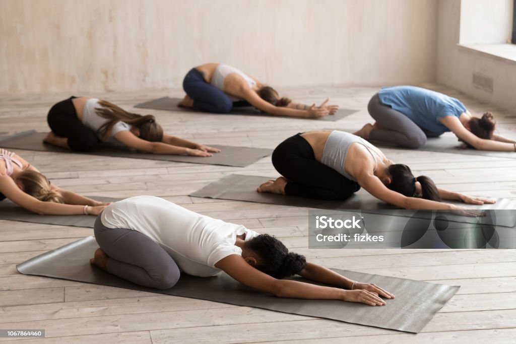 Gruppe von Frauen praktizieren Yoga in Balasana pose - Lizenzfrei Yoga Stock-Foto