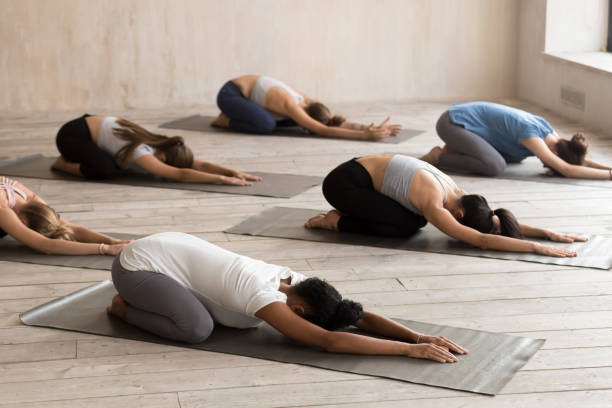 istock Group of women practicing yoga in Balasana pose 1067864460