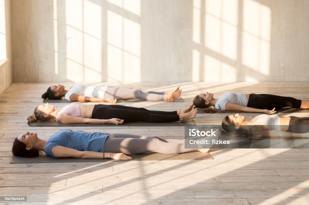 Gruppe von Jugendlichen üben Yoga Lektion Leiche zu tun - Lizenzfrei Liegen Stock-Foto