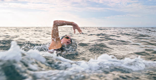 istock Female swimmer swimming forward crawl in sea 1067877478