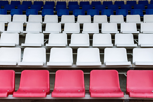 Stadium seats, France flag color. Soccer, football or baseball stadium tribune without fans. End of the game.