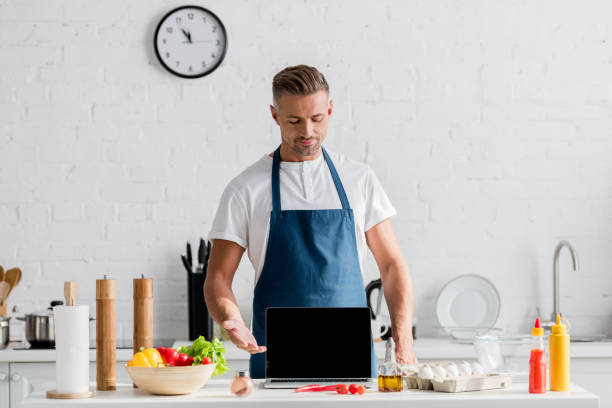 istock adult man with black screen on opened laptop standing at kitchen 1067884946