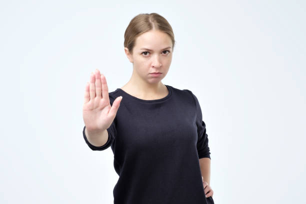istock Serious pretty woman making stop hand sign palm gesture 1067894458