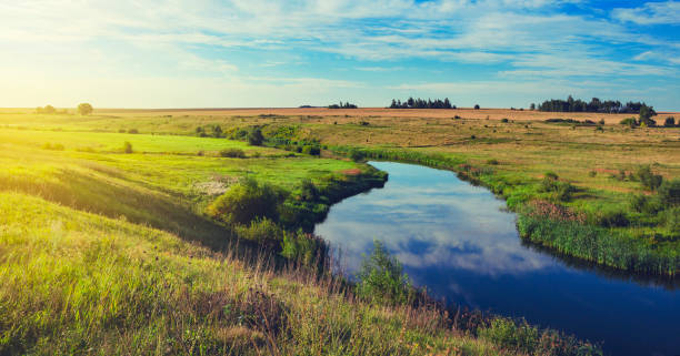 istock Sunny summer landscape with fields,green pastures,river and beautiful woods. 1067895096