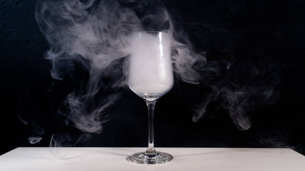 istock wine glas filled with smoke on a white table with a black background, smoke in glas, 1067899714