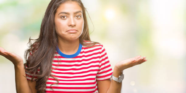 istock Young beautiful arab woman over isolated background clueless and confused expression with arms and hands raised. Doubt concept. 1067901248