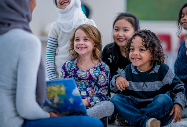 istock Muslim teacher reading to students 1067903936