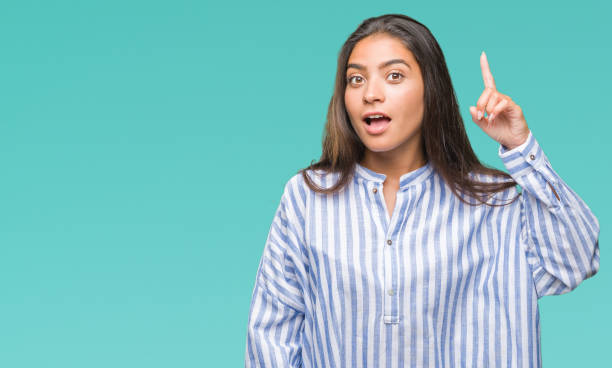 istock Young beautiful arab woman over isolated background pointing finger up with successful idea. Exited and happy. Number one. 1067904384