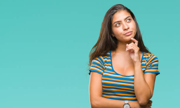 istock Young beautiful arab woman over isolated background with hand on chin thinking about question, pensive expression. Smiling with thoughtful face. Doubt concept. 1067904568