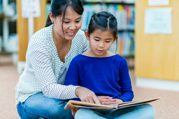 istock Mother and daughter at the library. 1067907116