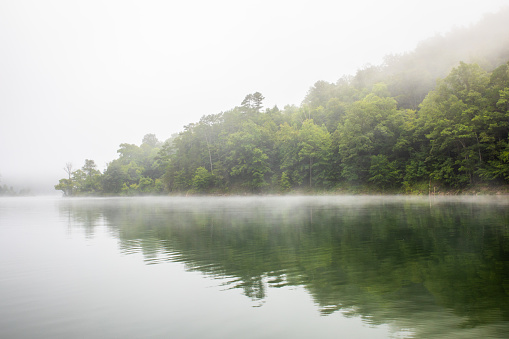 A light fog provides haze above the lake from a water in Central Appalachia.